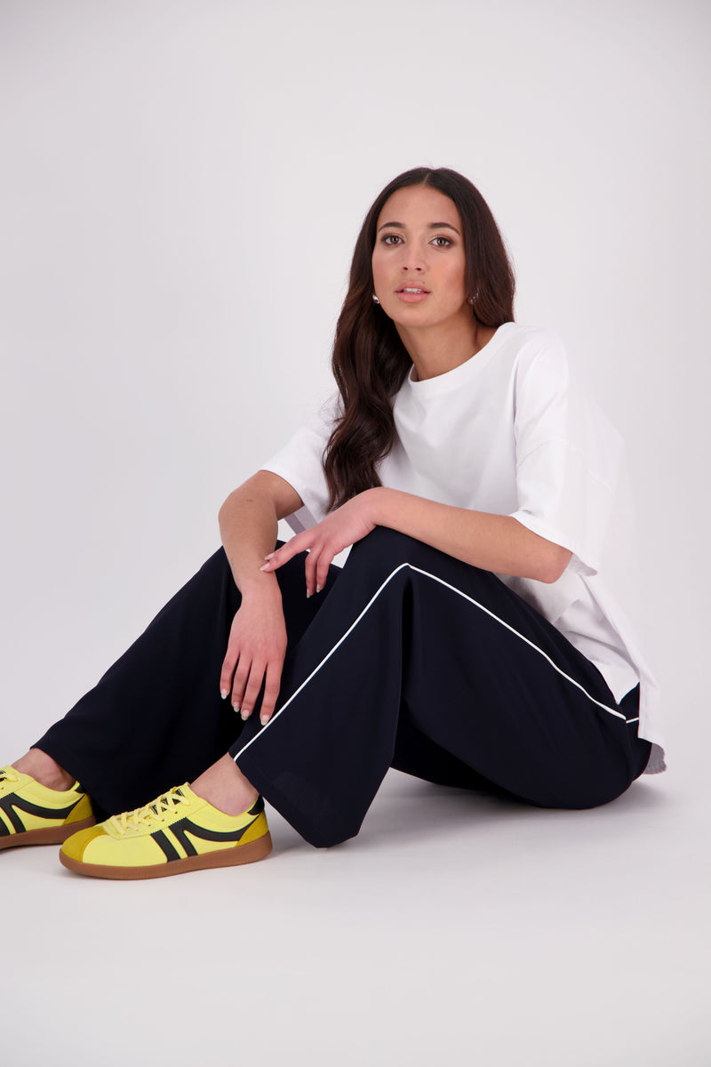 We’ve had some fun with our NES Gin Pants, adding a contrast side seam piping detail for a stylish twist on a classic design. These pants feature a flattering, classic cut that’s perfect for both dressing up and down, making them an ideal work pant and an effortless everyday style. With a flat front, covered elasticated back, and flattering angled pockets, they offer both comfort and sophistication.
Composition: 100% Polyester
Designed & Made in New Zealand