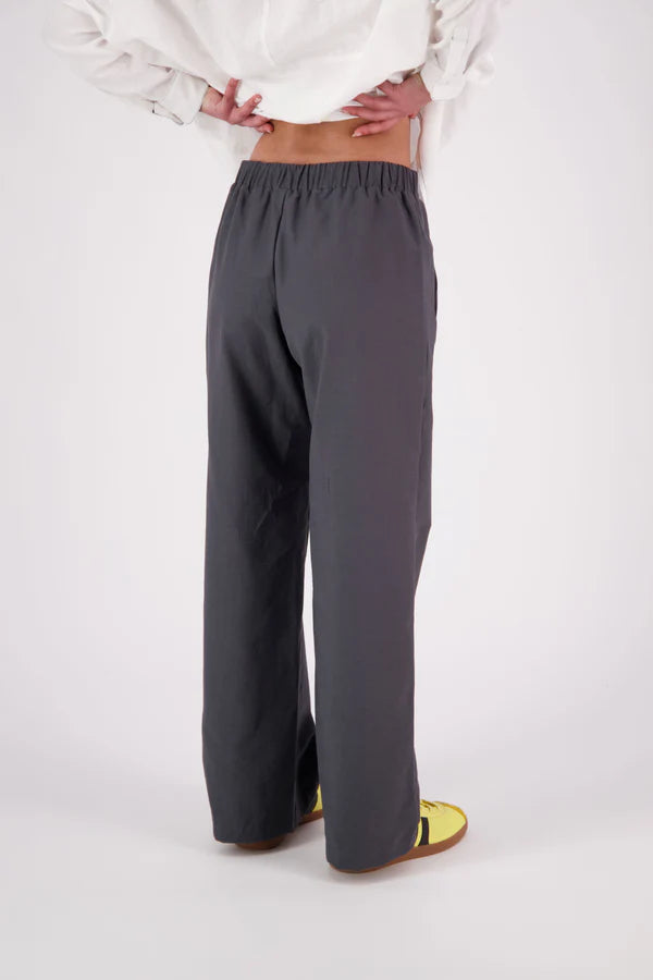 The N-E-S Gin Pants are a best-selling essential, designed to flatter all body shapes with a clean, classic cut. Featuring a flat front, elasticated back, and angled side pockets, they blend comfort and polish effortlessly. Made from a cotton blend, cool-to-the-touch, they're perfect for work, travel, or everyday wear. Whether dressed up or down, the Gin Pants are your go-to for timeless style and all-day ease.

Our model is 174cm and wear a XS (8)

Composition: cotton nylon
Designed and Made in New Zealand