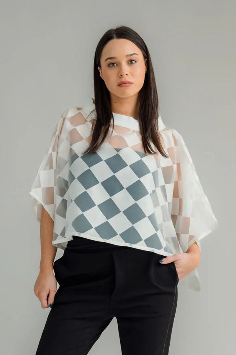the NES Kio Top, a playful twist on our best-selling Bioko Top. Featuring a chic tube neck, stitched-in armholes, and a stylish high-low hem, Kio is the ultimate wardrobe must-have. Perfect for adding instant style and coverage, Kio layers effortlessly over any tank-style top or dress. Whether dressing up or down, the NES Kio Top combines versatility with fashion flair, making it a go-to piece for any occasion. A must-have addition to your collection for effortless sophistication!