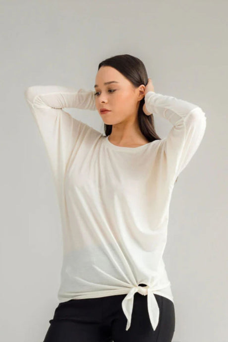 The NES Merino Leisure Tie Top is a stylish and versatile piece, perfect for pairing with your favourite denim, Dolly B pants, Drilled Gin pants, or the Ribs skirt. This top features a self-tie at the side that can be adjusted to your liking—tied tight for a more structured look or looped loose for a relaxed feel. With its batwing design and cigarette sleeves, it offers a flattering silhouette that adds slimness to your lower arms while providing maximum comfort. 100% merino