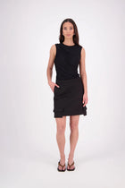 The N-E-S Demi Skirt is a fresh take on utilitarian style, reimagined as a flattering mini. Designed with a curved waistband for a versatile fit across body shapes, it features side seam pockets, a concealed centre back zip, and bold hem pocket detailing with Black buttons. Falling just above the knee, it’s the perfect mix of function and style.

Our model is 174cm and wear a XS (8)

Composition: cotton, spandex&nbsp;

Designed and Made in New Zealand