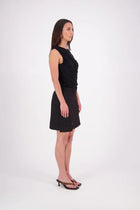 The N-E-S Demi Skirt is a fresh take on utilitarian style, reimagined as a flattering mini. Designed with a curved waistband for a versatile fit across body shapes, it features side seam pockets, a concealed centre back zip, and bold hem pocket detailing with Black buttons. Falling just above the knee, it’s the perfect mix of function and style.

Our model is 174cm and wear a XS (8)

Composition: cotton, spandex&nbsp;

Designed and Made in New Zealand