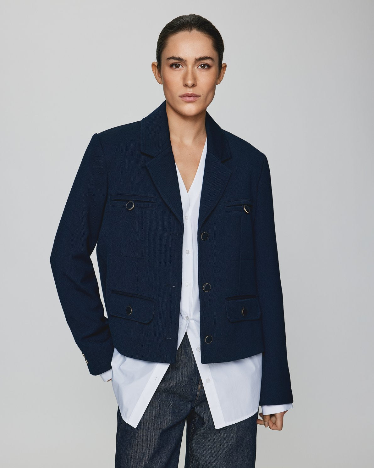 MSCH | ELINA BLAZER

A short, navy blue blazer with dark blue buttons with gold rim. These buttons is both down the front and on the cuffs. The blazer features a front pocket design inspired by a military jacket. Style it with a pair of jeans for a cool and causal look or with the matching skirt.

This blazer has a boxy fit. The model is 177cm and wears a size S.

Composition: 50% Recycled Polyester, 35% Viscose &amp; 15% Polyester