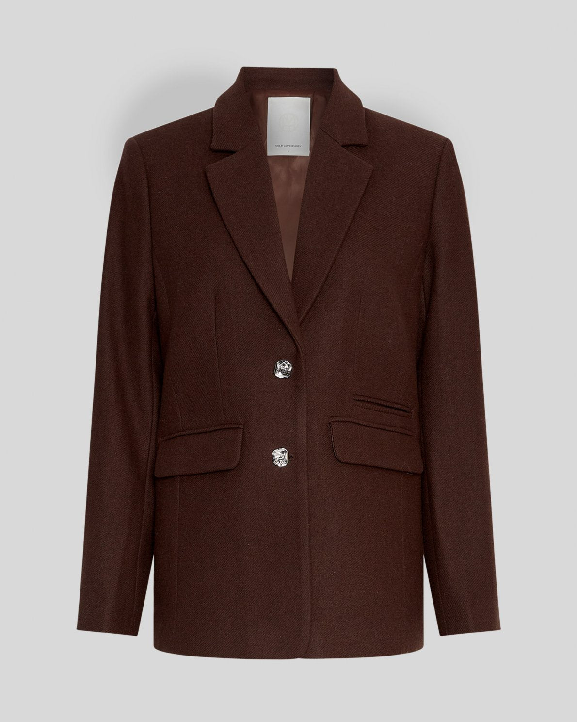 MSCH Copenhagen ELLIOT Loose Blazer in brown with a straight structured silhouette and classic notched lapels. Features a front button closure, flap pockets and full lining for a smooth tailored finish. Crafted from a recycled polyester, wool and viscose blend.