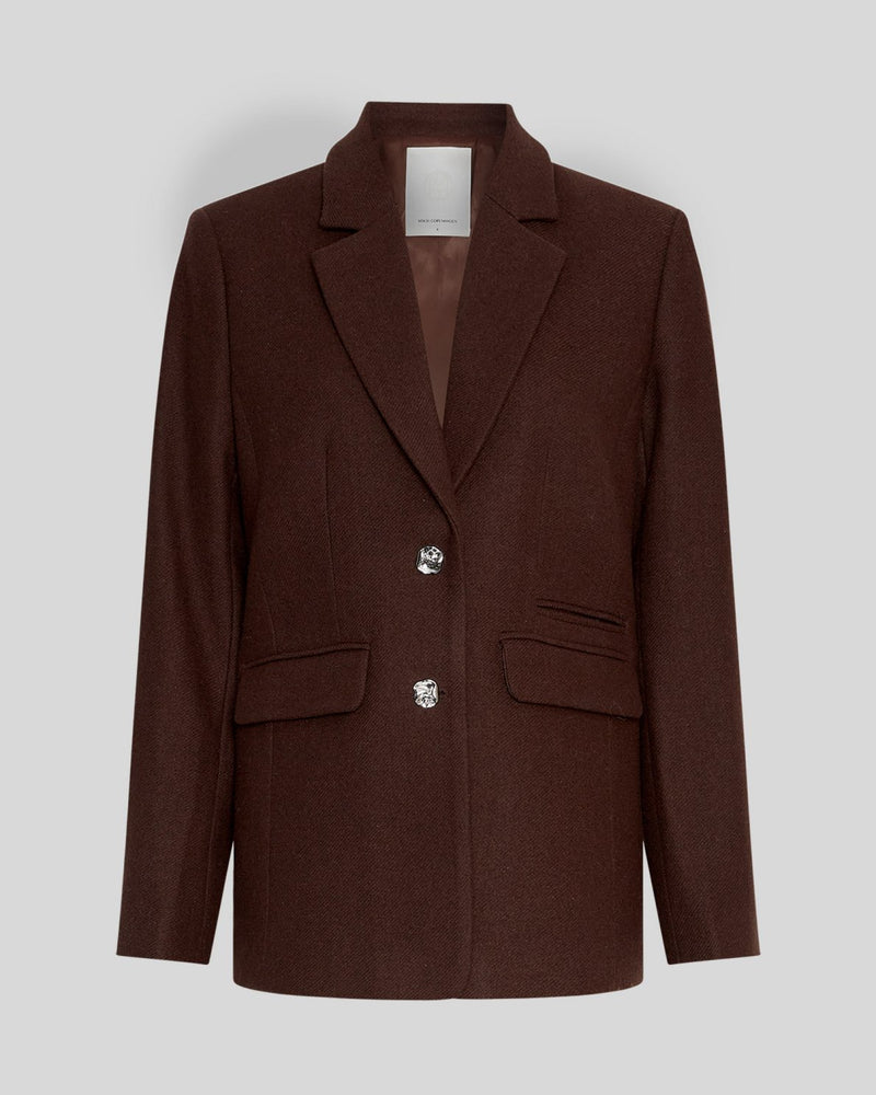 MSCH Copenhagen ELLIOT Loose Blazer in brown with a straight structured silhouette and classic notched lapels. Features a front button closure, flap pockets and full lining for a smooth tailored finish. Crafted from a recycled polyester, wool and viscose blend.