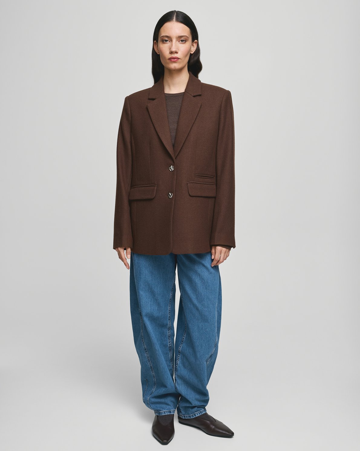 MSCH Copenhagen ELLIOT Loose Blazer in brown with a straight structured silhouette and classic notched lapels. Features a front button closure, flap pockets and full lining for a smooth tailored finish. Crafted from a recycled polyester, wool and viscose blend.