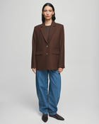 MSCH Copenhagen ELLIOT Loose Blazer in brown with a straight structured silhouette and classic notched lapels. Features a front button closure, flap pockets and full lining for a smooth tailored finish. Crafted from a recycled polyester, wool and viscose blend.