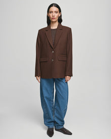 MSCH Copenhagen ELLIOT Loose Blazer in brown with a straight structured silhouette and classic notched lapels. Features a front button closure, flap pockets and full lining for a smooth tailored finish. Crafted from a recycled polyester, wool and viscose blend.