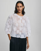MSCH Copenhagen ISMENE 3/4 Shirt EMB in white, crafted from a lightweight semi-sheer fabric with delicate embroidered floral detailing. Designed with a round neckline and full front button closure, featuring 3/4-length volume sleeves with elastic cuffs and an oversized airy fit.