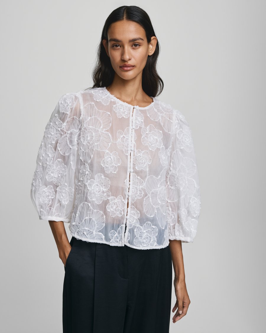 MSCH Copenhagen ISMENE 3/4 Shirt EMB in white, crafted from a lightweight semi-sheer fabric with delicate embroidered floral detailing. Designed with a round neckline and full front button closure, featuring 3/4-length volume sleeves with elastic cuffs and an oversized airy fit.