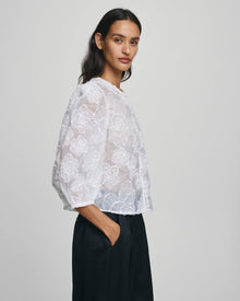MSCH Copenhagen ISMENE 3/4 Shirt EMB in white, crafted from a lightweight semi-sheer fabric with delicate embroidered floral detailing. Designed with a round neckline and full front button closure, featuring 3/4-length volume sleeves with elastic cuffs and an oversized airy fit.