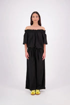 The N-E-S Muses Jumpsuit features a shirred off-the-shoulder top with cap sleeves, an elasticated back waist, and a self-drawcord front for a flattering, adjustable fit. The lower half mirrors the relaxed fit of our Lounge Jumpsuit, with angled seams, centre front detailing, and practical front pockets—plus 5cm added length for extra ease. Wear it your way: off the shoulders, asymmetrical, or pulled up for a more classic neckline.
lyocell,rayon,nylon,linen (anti-crease)
Designed & made in New Zealand
