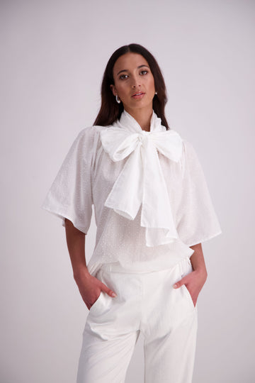 The N-E-S Nova Shirt blends the best of our Ayla, Mon, and Del shirts into one must-have wardrobe piece. Featuring elbow-length sleeves, a soft drop hem at the front and back, and a playful neck tie that can be styled multiple ways—bowed, looped, or reversed and tied at the back. Designed for versatility and charm, the Nova Shirt is a timeless addition to elevate your everyday style.

Our model is 174cm and wear a XS/S (8-10)

Composition: Cotton

Designed and Made in New Zealand