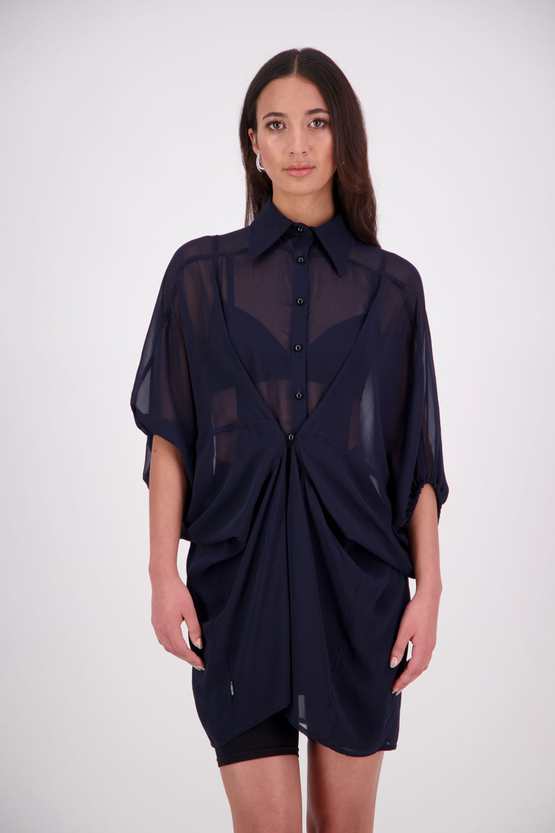 The N-E-S Oby Shirt Dress is a floaty chiffon piece with a batwing silhouette and tunic-length finish. Designed with a classic collar and centre front button-through placket, it features a waist loop and button so you can wear it loose and open or cinched for a more defined shape. Great worn on its own or styled back with slim or wide leg trousers or denim shorts for a relaxed, effortless look.

Our model is 174cm and wears a XS/S (8-10)

Composition: PT Chiffon

Designed and Made in New Zealand