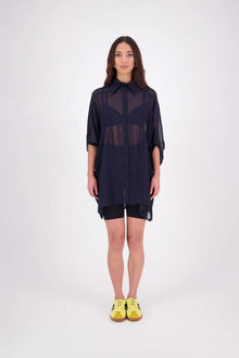 The N-E-S Oby Shirt Dress is a floaty chiffon piece with a batwing silhouette and tunic-length finish. Designed with a classic collar and centre front button-through placket, it features a waist loop and button so you can wear it loose and open or cinched for a more defined shape. Great worn on its own or styled back with slim or wide leg trousers or denim shorts for a relaxed, effortless look.

Our model is 174cm and wears a XS/S (8-10)

Composition: PT Chiffon

Designed and Made in New Zealand