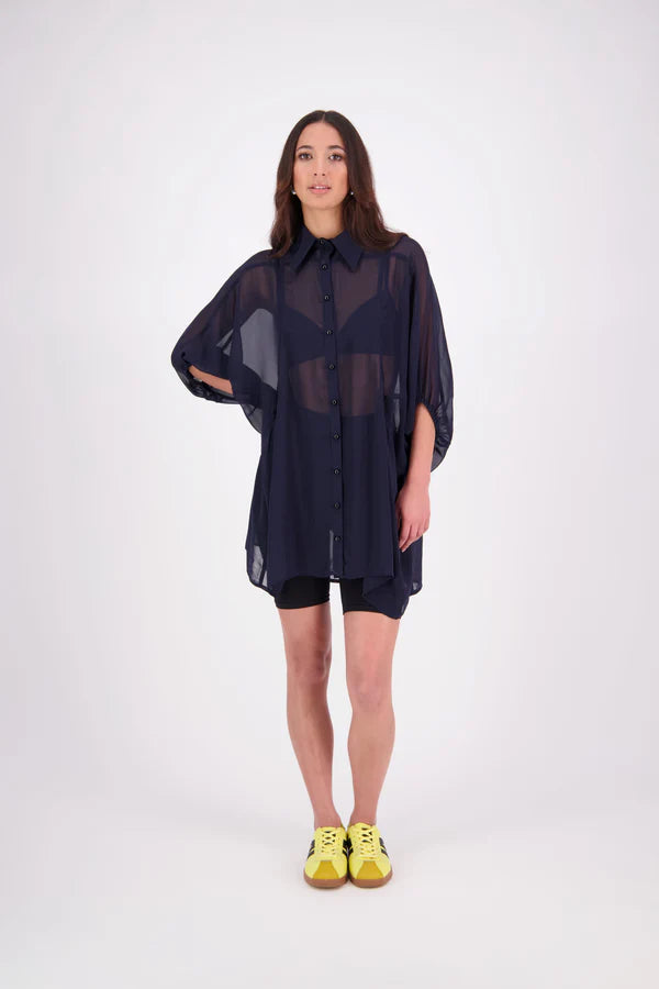 The N-E-S Oby Shirt Dress is a floaty chiffon piece with a batwing silhouette and tunic-length finish. Designed with a classic collar and centre front button-through placket, it features a waist loop and button so you can wear it loose and open or cinched for a more defined shape. Great worn on its own or styled back with slim or wide leg trousers or denim shorts for a relaxed, effortless look.

Our model is 174cm and wears a XS/S (8-10)

Composition: PT Chiffon

Designed and Made in New Zealand