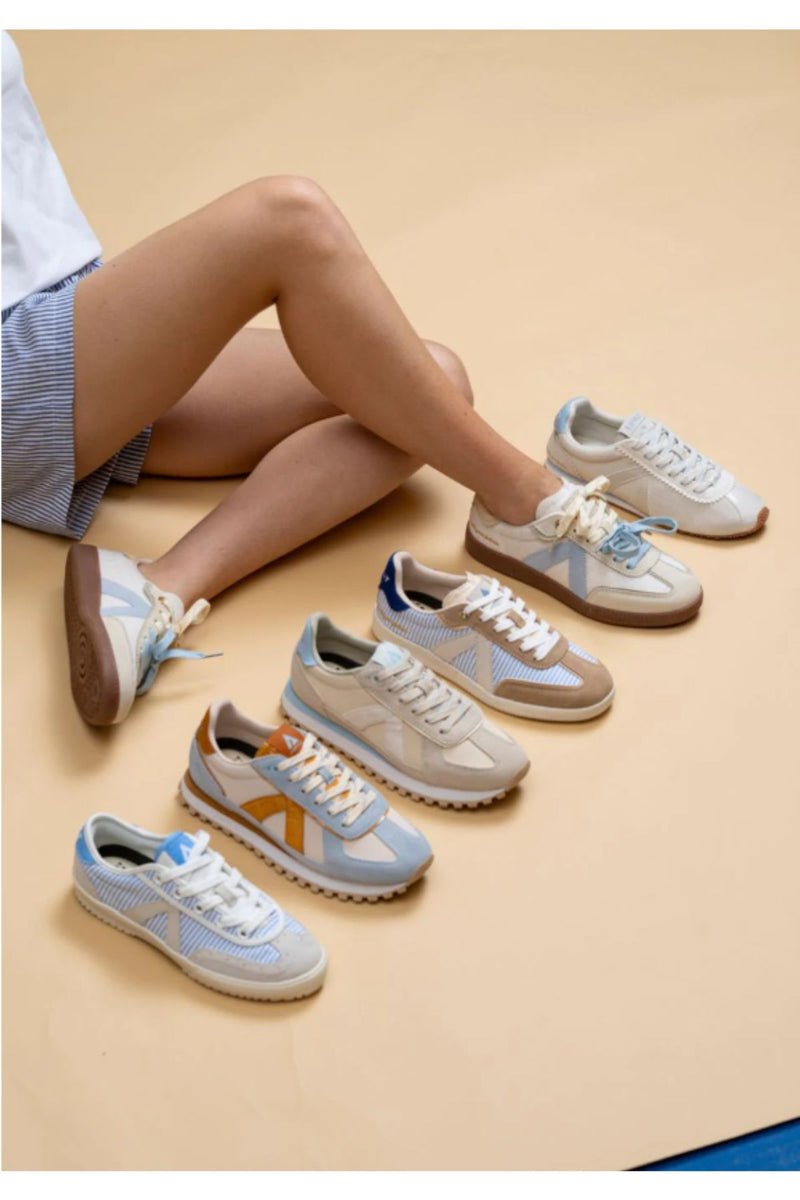 ASFVLT ELITE CLASSIC sneaker in cream pony hair–style finish, featuring a soft textured upper with suede overlays and subtle light blue side accents. The retro-inspired silhouette sits on a classic gum sole and includes a distinctive double-lace design with contrasting laces for a layered, fashion-forward look. Lightweight and versatile, it blends vintage appeal with modern street style.