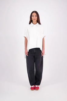 Ryn cotton Shirt – Effortless Volume & Soft Structure

The N-E-S Ryn Shirt is a modern take on a classic, crafted in breathable cotton. With its umbrella-style silhouette, it features a centre front button-down placket, kimono-style sleeves gathered into soft cuffs, and a slight high-low hem. Easy to style back with pants, shorts, or skirts—this is your go-to shirt for relaxed yet elevated dressing.