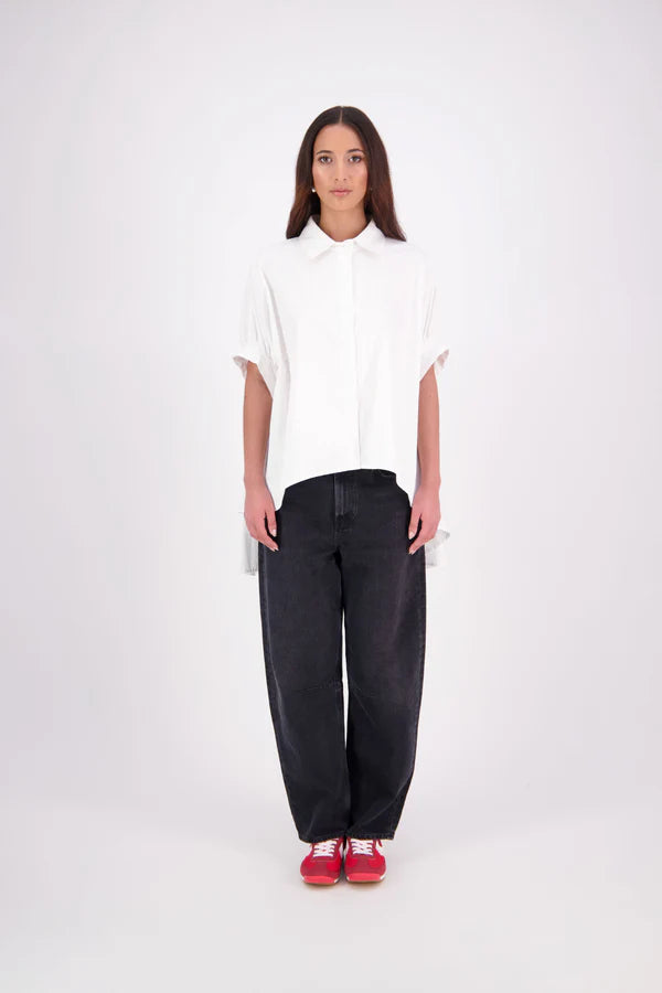 Ryn cotton Shirt – Effortless Volume & Soft Structure

The N-E-S Ryn Shirt is a modern take on a classic, crafted in breathable cotton. With its umbrella-style silhouette, it features a centre front button-down placket, kimono-style sleeves gathered into soft cuffs, and a slight high-low hem. Easy to style back with pants, shorts, or skirts—this is your go-to shirt for relaxed yet elevated dressing.