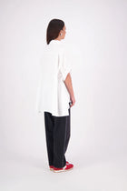 Ryn cotton Shirt – Effortless Volume & Soft Structure

The N-E-S Ryn Shirt is a modern take on a classic, crafted in breathable cotton. With its umbrella-style silhouette, it features a centre front button-down placket, kimono-style sleeves gathered into soft cuffs, and a slight high-low hem. Easy to style back with pants, shorts, or skirts—this is your go-to shirt for relaxed yet elevated dressing.