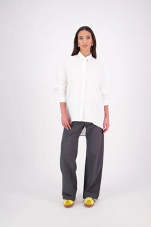 Zola cotton Shirt – Effortless Volume, Elevated Detail

The N-E-S Zola Shirt is a kimono-style oversized shirt with a relaxed, modern silhouette. Featuring a horizontal drop-back panel for added movement, 7/8 sleeves, a classic collar, centre front button placket, and button-up cuffs. A versatile piece that blends structure with flow—perfect for layering or wearing as a statement on its own.